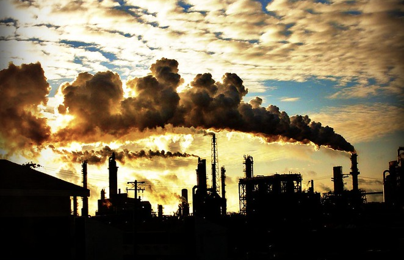 smoke stacks against cloudy sunny sky