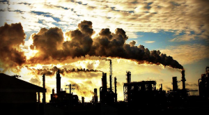 smoke stacks against cloudy sunny sky